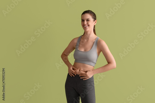 Sporty young woman on green background