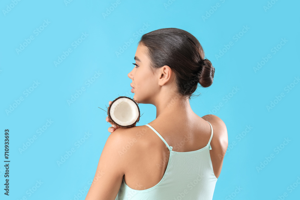 Beautiful young woman with coconut on blue background Beautiful young woman with coconut on blue background