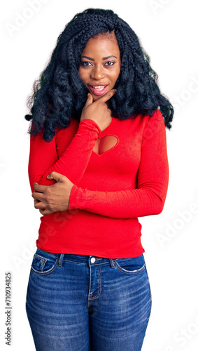 Beautiful african american woman wearing casual clothes looking confident at the camera smiling with crossed arms and hand raised on chin. thinking positive.