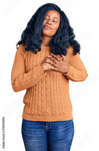 Beautiful african american woman wearing casual sweater smiling with hands on chest with closed eyes and grateful gesture on face. health concept.