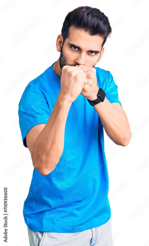 Young handsome man with beard wearing casual t-shirt ready to fight with fist defense gesture, angry and upset face, afraid of problem Young handsome man with beard wearing casual t-shirt ready to fight with fist defense gesture, angry and upset face, afraid of problem
