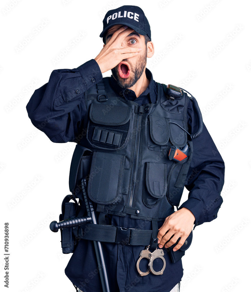 Young handsome man with beard wearing police uniform peeking in shock covering face and eyes with hand, looking through fingers with embarrassed expression. Young handsome man with beard wearing police uniform peeking in shock covering face and eyes with hand, looking through fingers with embarrassed expression.