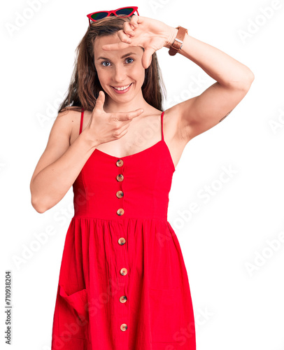 Young beautiful blonde woman wearing casual dress smiling making frame with hands and fingers with happy face. creativity and photography concept.