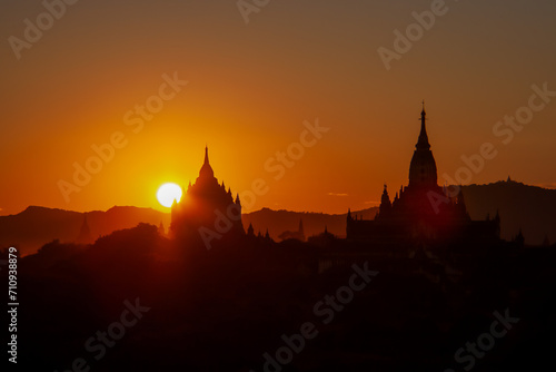 the dreamlike sunset in front of the shilouttes of the pagodas in bagan 