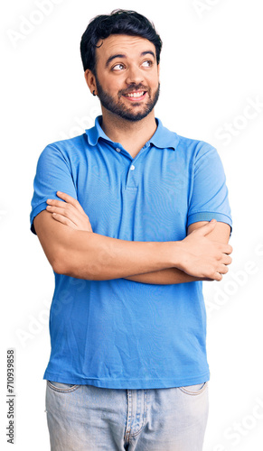 Young hispanic man wearing casual clothes smiling looking to the side and staring away thinking.