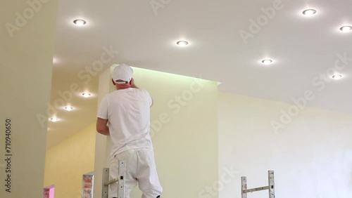 Worker is standing on scaffold and fixing the wall  photo