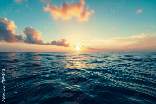 A picturesque view of the endless ocean with the horizon line under the bright western sky in the evening