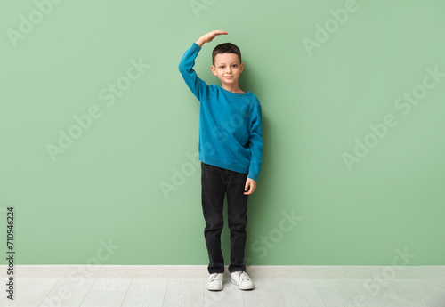 Cute little boy measuring h...