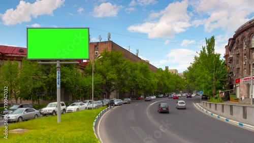 Wallpaper Mural Green screen billboard against the background of moving cars, green trees, buildings and white clouds in Spring. 4K TIME LAPSE video Torontodigital.ca