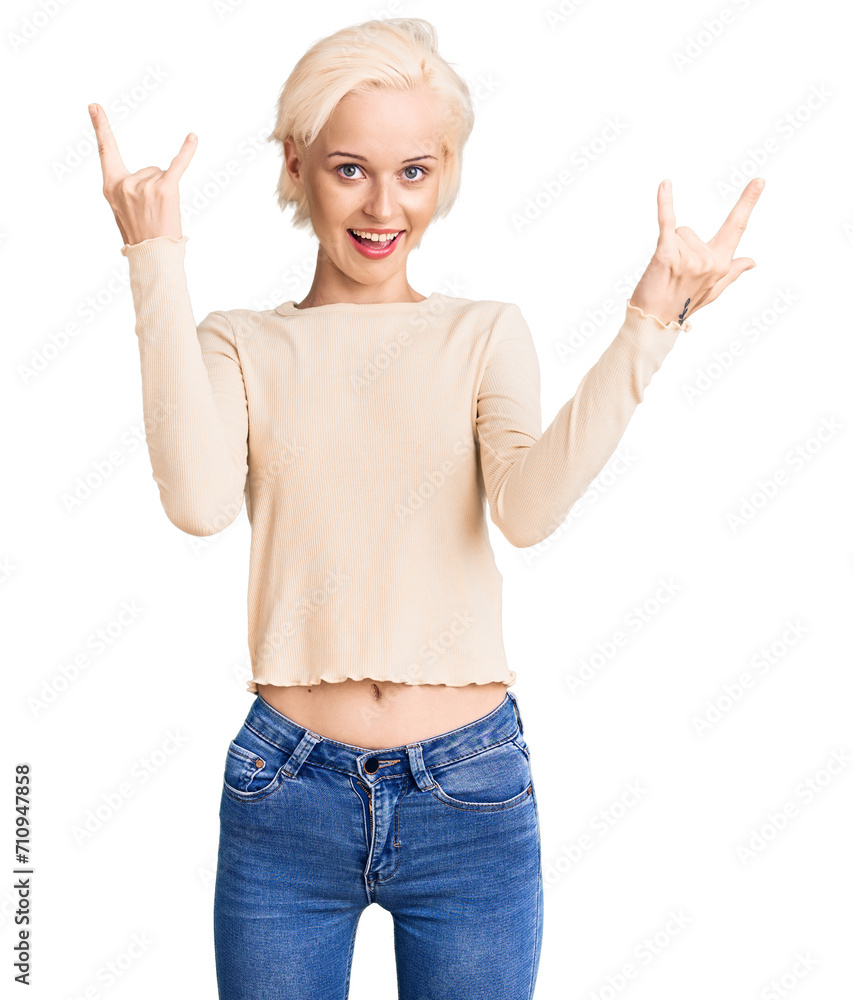 Young blonde woman wearing casual clothes shouting with crazy expression doing rock symbol with hands up. music star. heavy music concept. Young blonde woman wearing casual clothes shouting with crazy expression doing rock symbol with hands up. music star. heavy music concept.