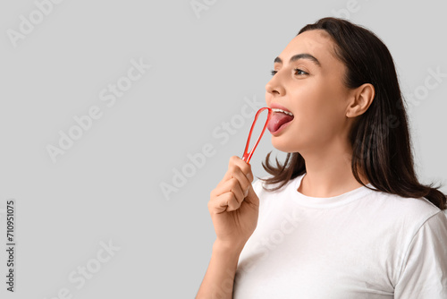 Young woman using tongue sc...