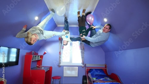 Father, mother, daughter, son with balloons at inverted house