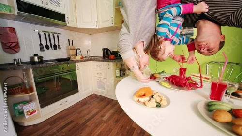 Father, mother and daughter upside down in inverted house