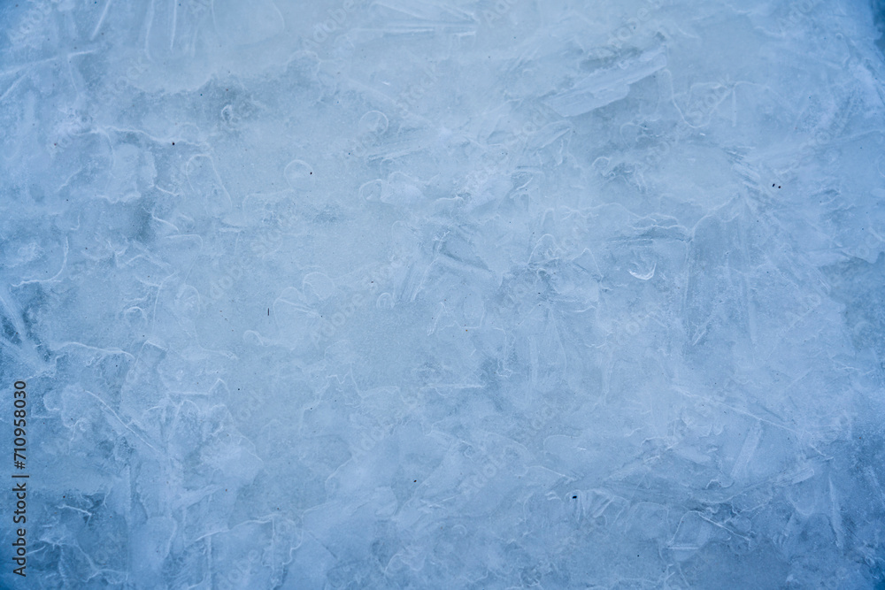 Icy winter background cracked grunge texture. Natural scratched ice on a skating rink as a texture or background for a winter composition, large long painting Icy winter background cracked grunge texture. Natural scratched ice on a skating rink as a texture or background for a winter composition, large long painting