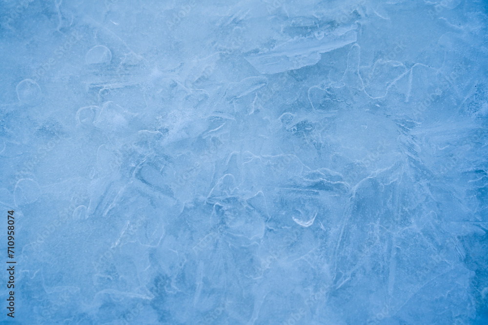 Icy winter background cracked grunge texture. Natural scratched ice on a skating rink as a texture or background for a winter composition, large long painting