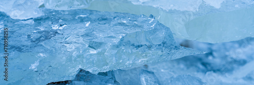 Icy winter background cracked grunge texture. Natural scratched ice on a skating rink as a texture or background for a winter composition, large long painting