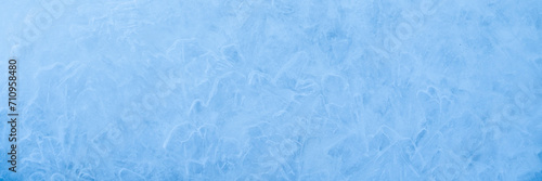 Icy winter background cracked grunge texture. Natural scratched ice on a skating rink as a texture or background for a winter composition, large long painting