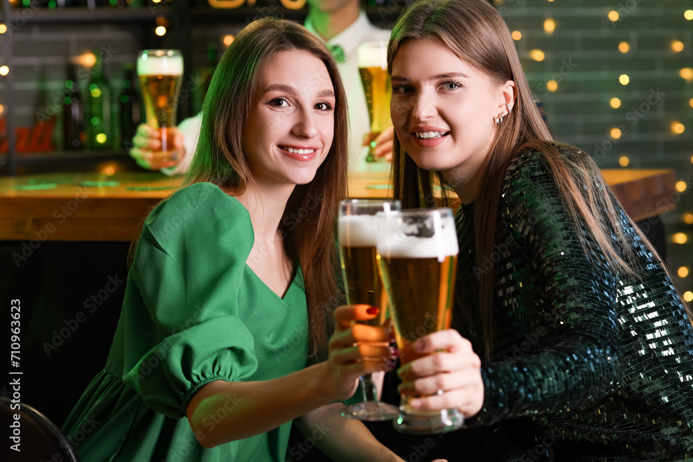 Young women with beer celebrating St. Patrick's Day in pub Young women with beer celebrating St. Patrick's Day in pub