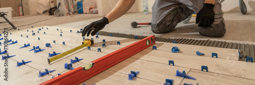 Repair and construction. Laying ceramic tiles using cement on the floor close-up. A man lays slabs on the floor and walls.