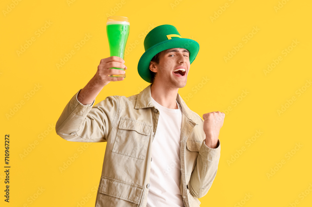 Young man with beer on yellow background. St. Patrick's Day celebration Young man with beer on yellow background. St. Patrick's Day celebration