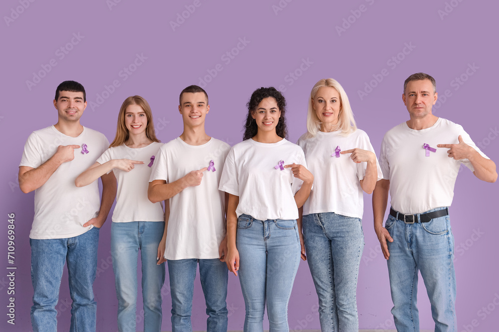 People pointing at lavender awareness ribbons on color background. World Cancer Day People pointing at lavender awareness ribbons on color background. World Cancer Day