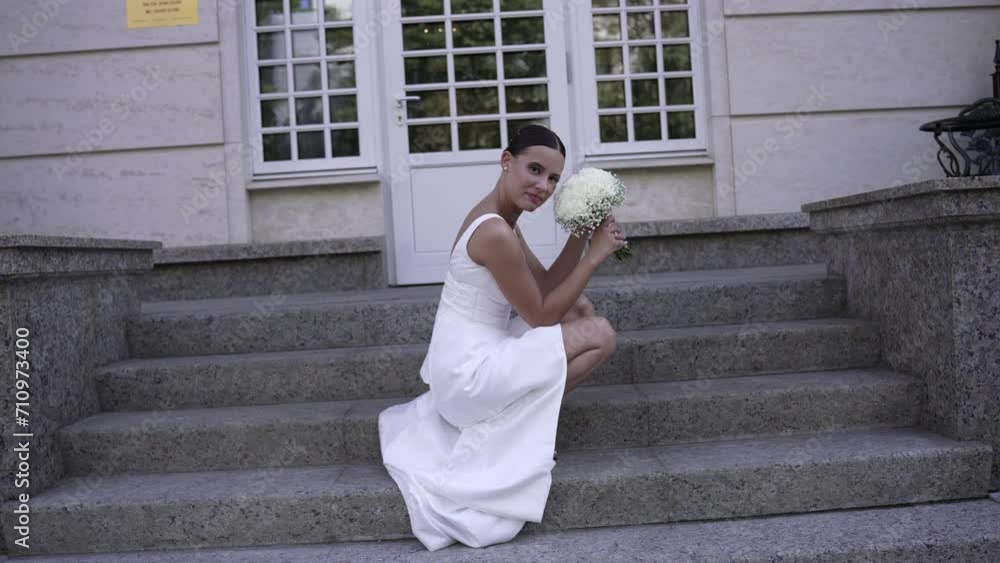 Bride in white long wedding dress with bouquet of flowers of pink roses Bride in white long wedding dress with bouquet of flowers of pink roses