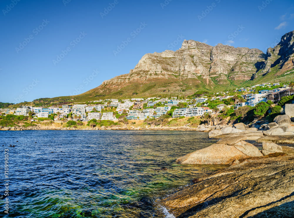 Bakoven beach and Camps Bay houses with the Twelve Apostles mountain in the background, Cape Town, South Africa