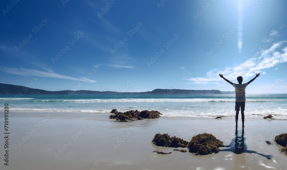 Generative AI image of a young person stands by the shoreline, gazing out at the expansive ocean. With arms outstretched and a peaceful smile, they exude a sense of trust in the higher power.