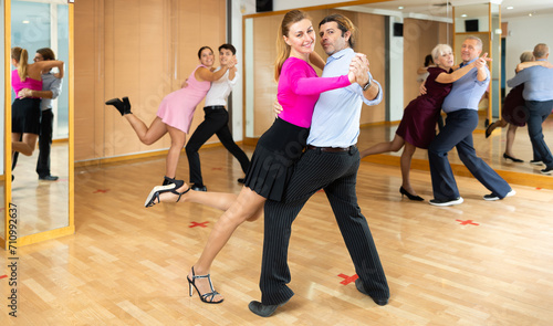 professional woman choreographer showing basic movements of latin samba dance to her students