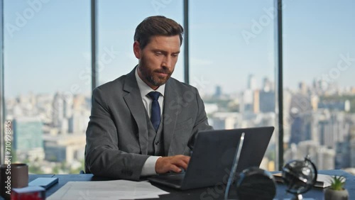 Office man starting day opening laptop lid. Successful entrepreneur working desk photo