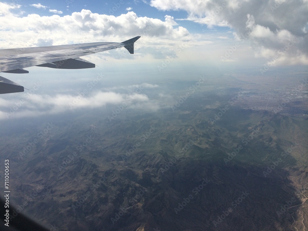 View from Airplane Window of Mountains and Clouds View from Airplane Window of Mountains and Clouds