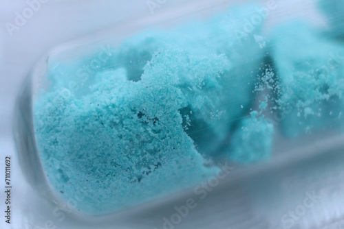 Turquoise salt nickel sulfate in the form of crystal hydrate in a test tube. photo