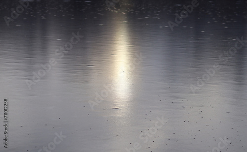 A ray of sunlight reflects off the surface of a frozen river.