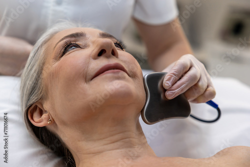 Mature gray-haired woman having a mesotherapy treatment