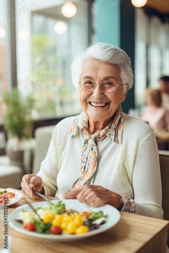 Portrait of a smiling elderly woman eating a salad
