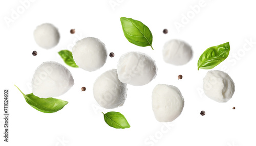 Mozzarella balls, basil leaves and peppercorns falling on white background photo