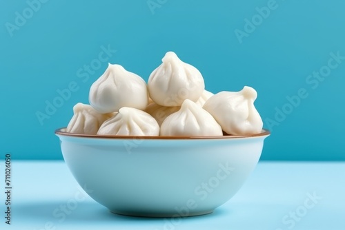 Dumplings with filling in a plate on a blue background. Concept: food made from dough is steamed. Calorie-rich food made from flour. Banner with copy space