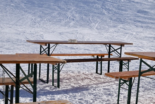 Glass ashtray on a wooden bench outside an apres ski bar. Sunny day in Obergurgl ski resort, Austria.