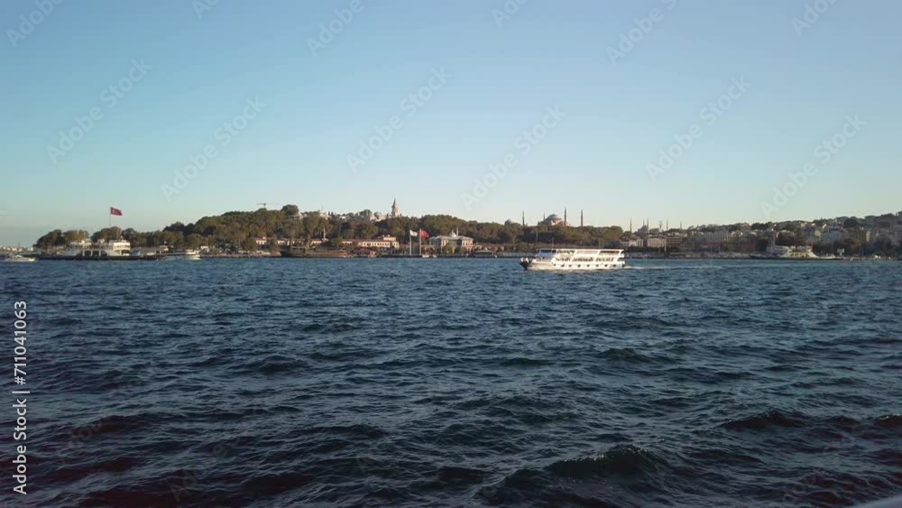 Evening, cinematic slow-mo, a mesmerizing view of Sarayburnu from a ferry on the Golden Horn in Istanbul. The shot showcases a ferry sailing left to right, Hagia Sophia and cityscape in background. Evening, cinematic slow-mo, a mesmerizing view of Sarayburnu from a ferry on the Golden Horn in Istanbul. The shot showcases a ferry sailing left to right, Hagia Sophia and cityscape in background.