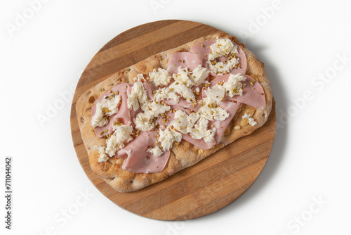 A piece of a traditional pizza of the Roman tradition, known as Pinsa Romana,with Mortadella of Bologna, mozzarella cheese Pistacchio grains, vision from above on white background and cutting board