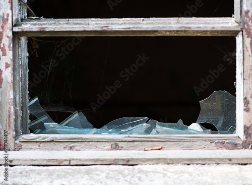 Smashed glass Window with old wooden frame. old window. finely broken glass. old house, retro. cracked window frame. cracked old paint, pieces of glass. close-up, space for text. large pieces of glass