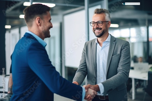 Two businessmen shaking hands in an office photo