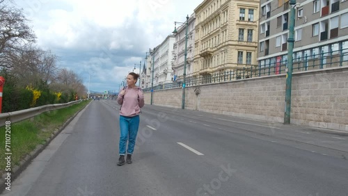 Woman walk along budapest buildings. A woman tourist go for a walk along the city street with Europe buildings in the day light. photo