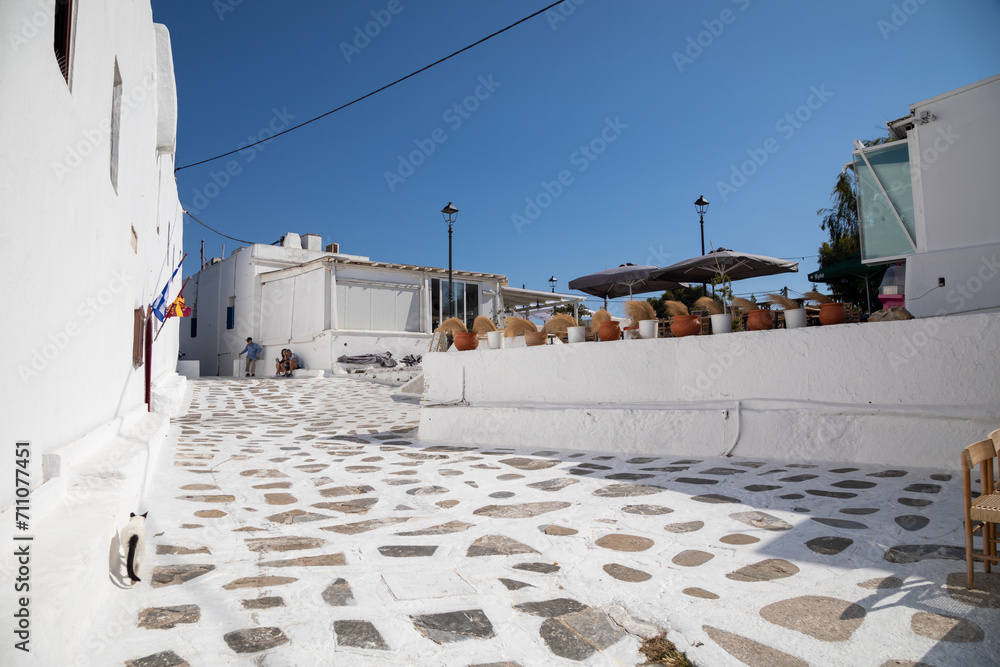 Streetview of Mykonos town with white street and blue door, Greece