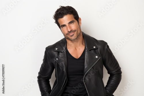 Portrait of a handsome young man in a leather jacket on a white background © Iigo