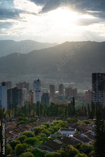 beautiful sunset over the mountains in medellin colombia in the poblado with trees and buildings in foreground in el poblado