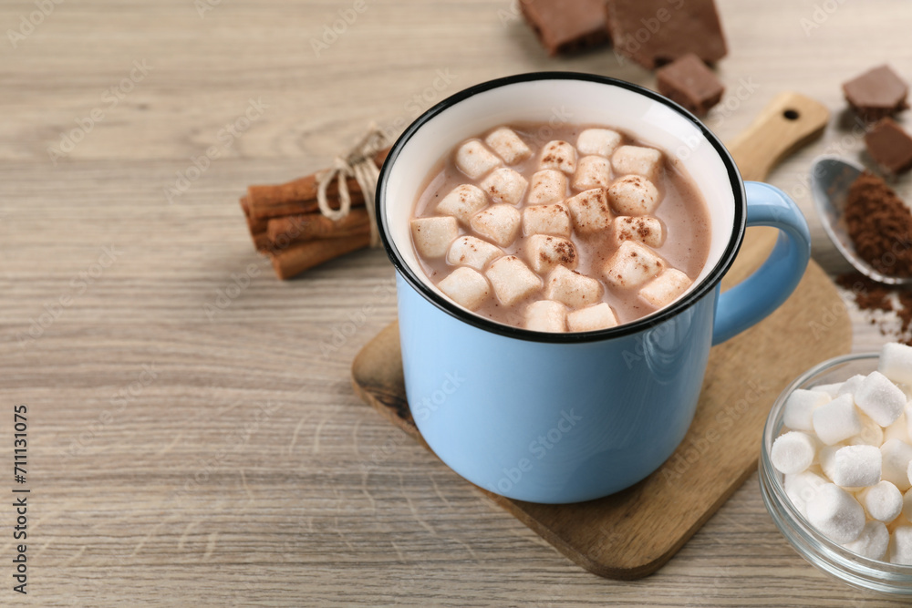 Cup of aromatic hot chocolate with marshmallows, and cocoa powder on wooden table, closeup. Space for text Cup of aromatic hot chocolate with marshmallows, and cocoa powder on wooden table, closeup. Space for text