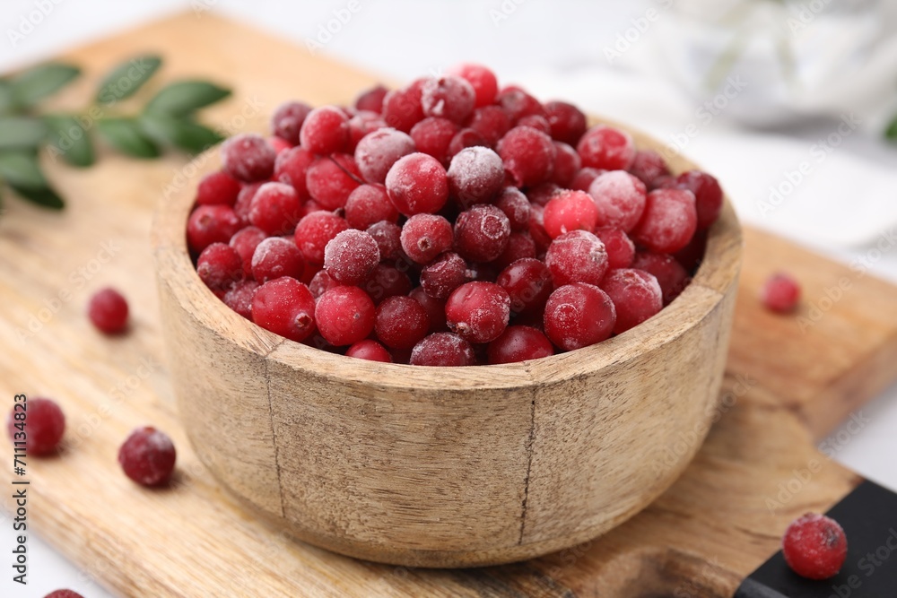 Frozen red cranberries in bowl on table, closeup Frozen red cranberries in bowl on table, closeup