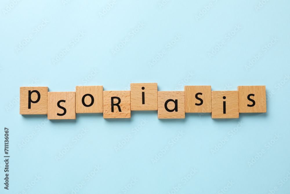 Word Psoriasis made of wooden squares with letters on light blue background, top view Word Psoriasis made of wooden squares with letters on light blue background, top view