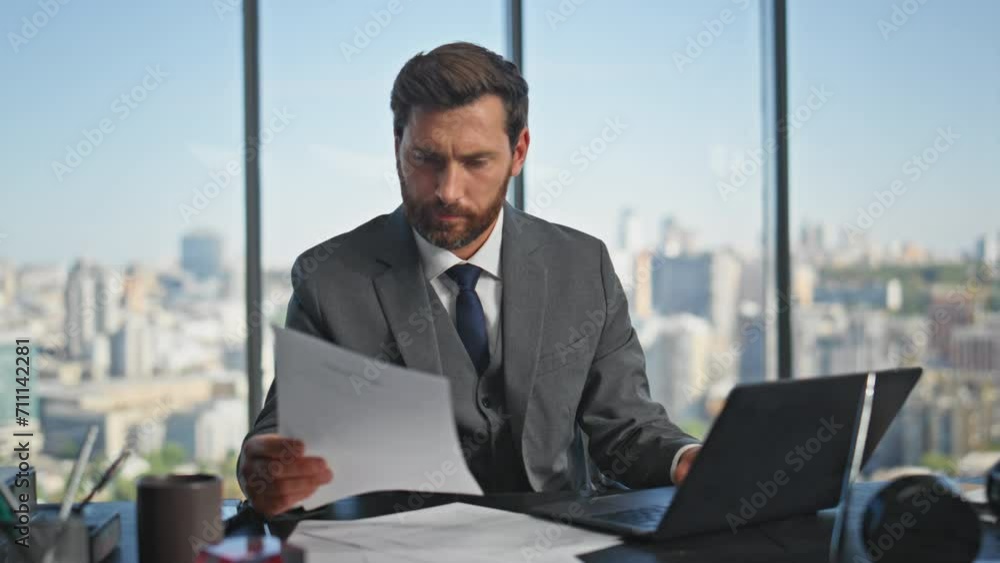 Stressed entrepreneur looking mistake doing paper work in contemporary office. Stressed entrepreneur looking mistake doing paper work in contemporary office.